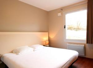 皮什朗德奥克斯巴肯杜桑西公寓式酒店的卧室配有一张大白色床和窗户