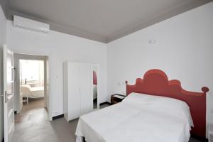 米兰卡特尔莱特住宿加早餐旅馆的卧室配有白色的床和红色床头板