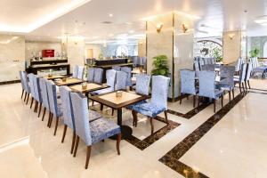 洞海皇家广平酒店 的一间配备有蓝色椅子和桌子的用餐室