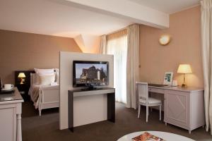 圣伊波利特洛吉酒店公园及Spa的酒店客房设有电视和床。