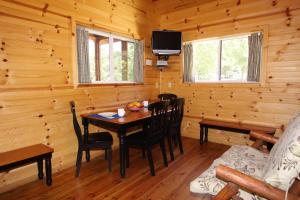 West SalemNeshonoc Lakeside Camping Resort的小木屋内带桌子的用餐室