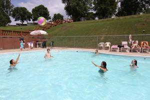 West SalemNeshonoc Lakeside Camping Resort的一群女人在游泳池里,带着球