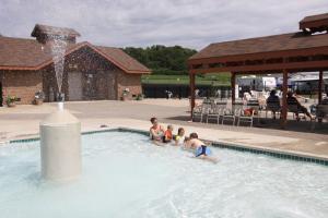 West SalemNeshonoc Lakeside Camping Resort的一群儿童在一个带喷泉的游泳池里