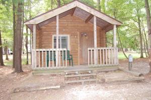 MarysvilleSt. Clair Camping Resort的树林中的小木屋,配有两把椅子