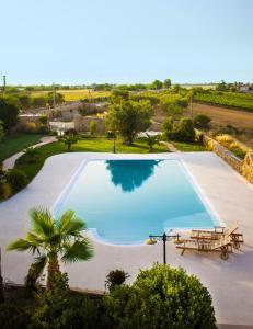 卡斯泰拉内塔Masseria D'Aprile的一个带野餐桌和长凳的大型游泳池