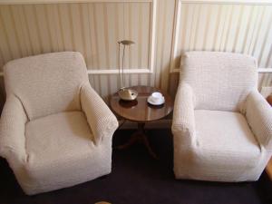 塔尔努夫Ricardpol Noclegi的客房内的2把白色椅子和1张桌子