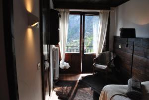 瓦托内切Hotell Millefiori- Alpine Event Lodge的卧室设有窗户、一张床和椅子