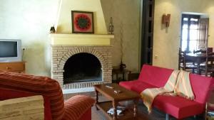 La NavaCasa Rural del Rio的客厅设有壁炉和红色家具。