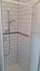 英格尔顿The Wheatsheaf Inn的浴室设有白色瓷砖淋浴。