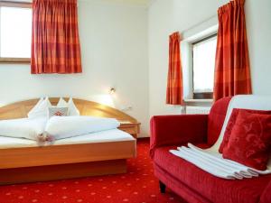雷西亚Pension Apartment Erna的酒店客房,配有一张床和一张红色的沙发