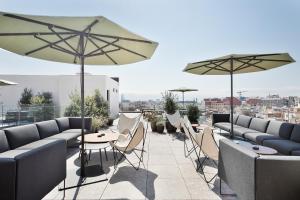 巴塞罗那约尔班帕萨基Spa酒店的一个带桌椅和遮阳伞的屋顶露台