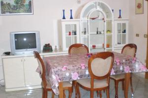 奥里亚Villino Monte San Michele的一间带桌椅和电视的用餐室