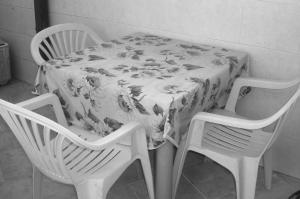 奥里亚Villino Monte San Michele的一张桌子,上面有花卉桌布,还有两把椅子