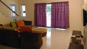 金宝J＆P一号旅馆的客厅配有紫色窗帘和沙发