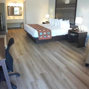 佛罗里达市佛罗里达/霍姆斯特德/大沼泽地温德姆速8汽车旅馆的酒店客房配有一张床、一张桌子和一把椅子。