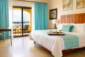 马萨特兰Las Villas Hotel & Golf By Estrella del Mar的一间卧室配有一张床,上面放着一个食物托盘