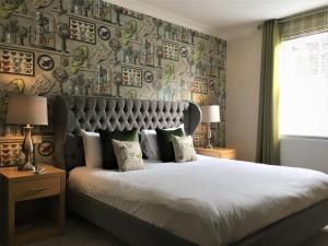史云顿海沃思酒店的一间卧室设有一张大床和一堵板墙
