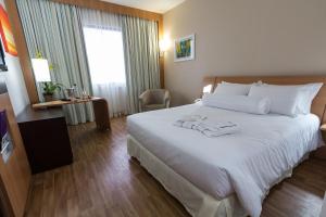 阿雷格里港诺富特阿雷格里波特酒店 的酒店客房带一张大床,带白色床单