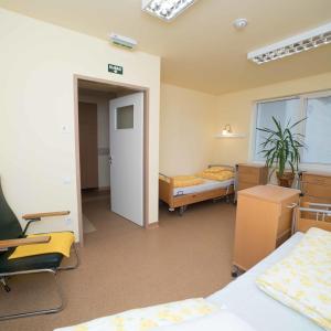 尼赖吉哈佐Borbányai Rehabilitációs Ház的客房设有两张床、一张桌子和椅子。