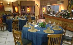 伊利亚贝拉Ilha Flat Hotel-Ilhabela apart Schiavettii的餐厅设有蓝色的桌椅,并备有帽子