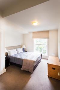 惠灵顿露台别墅服务式公寓的一间卧室设有一张大床和一个窗户。