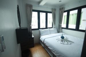 曼谷达林旅舍的一间卧室,配有一张床和花瓶