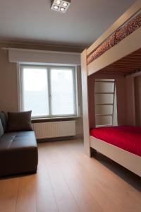 东代恩凯尔克De Witte Parel的一间带两张双层床和一张沙发的卧室