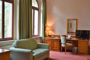 德累斯顿阿图斯霍夫酒店的客厅配有椅子和书桌