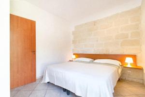 新福卡Casa Vacanze Mare e Ulivi的砖墙房间内的一张白色床