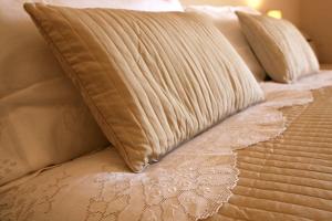 圣斯特凡诺·迪塞斯圣科伦坡修道院酒店的床上有枕头