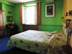 迪涅莱班Hotel De Provence的一间卧室设有一张带绿色墙壁和窗户的床。