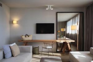佩雷拉达佩拉拉达葡萄酒Spa&高尔夫酒店的客厅配有桌子和墙上的电视