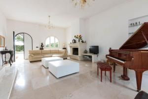 莱乌卡Villa Maria Clara by Perle di Puglia的客厅配有钢琴和沙发