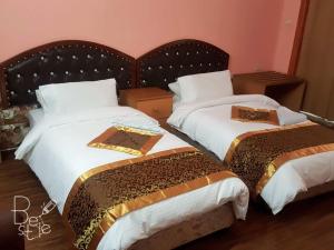 纳布卢斯Crystal Hotel فندق كريستال的一间卧室配有两张带棕色和白色床单的床