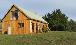 霍巴特查尔斯鲁本乡村民宿的田野上带绿色屋顶的木制谷仓