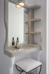 阿波罗尼亚索桑纳旅馆的浴室配有带镜子的盥洗盆和凳子