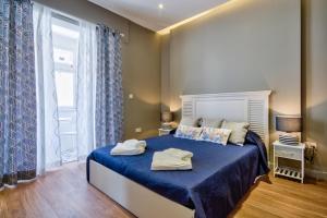 斯利马Amazing 4-bedroom Sliema Town House with Jacuzzi的一间卧室配有一张带蓝色床单的床和一扇窗户。