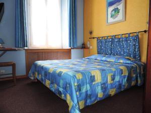 迪涅莱班Hotel De Provence的一间卧室配有一张蓝色和黄色的床罩