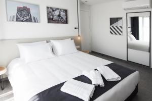 塞萨洛尼基White Luxury的卧室配有带毛巾的大型白色床