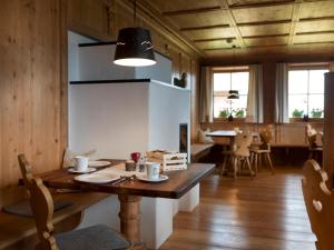 圣坎迪朵Bauernhof Zwiglhof的一间带木桌和椅子的用餐室以及一间用餐室