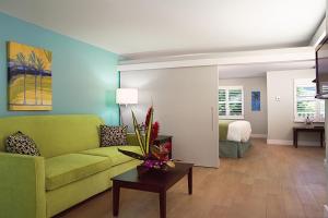 基韦斯特银色棕榈树酒店的一间带绿色沙发的客厅和一间卧室