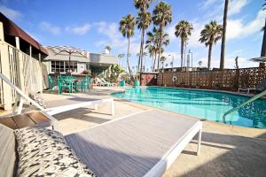 圣地亚哥海洋别墅旅馆的一个带长椅和棕榈树的游泳池