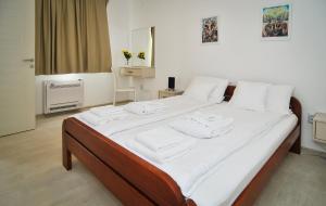 蒂瓦特Apartments Zukovac的一张配有白色床单和毛巾的大床