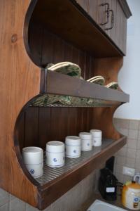 曼杜里亚L'Antica Casa Di Cosmarita的厨房里的架子上放着一捆杯子