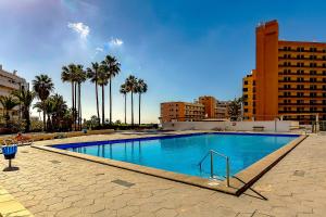 美洲海滩Viña del Mar Ocean的一座棕榈树和建筑的大型游泳池