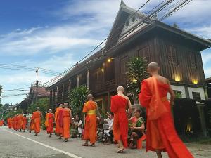 琅勃拉邦古老的琅勃拉邦宾馆的一群穿着橙色长袍的人在街上走