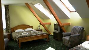 图库姆斯图库姆斯酒店的一间卧室设有一张床、一台电视和天窗。