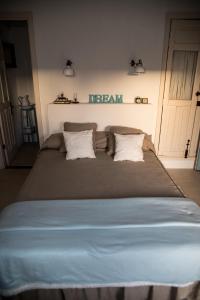 阿德耶Casa Leandra con jacuzzi的一张大床,配有两个枕头,墙上有一个梦幻标志
