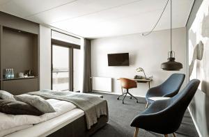罗斯基勒卡姆维尔克罗斯基勒酒店的一间卧室配有一张床、两把椅子和一张书桌