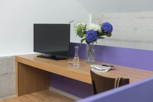 伦茨堡拜拉库达酒店的一张桌子,带有一台电视和花瓶